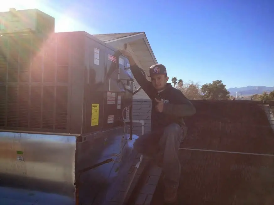 HVAC technician performing Boiler Repair on a rooftop unit in Palm Coast